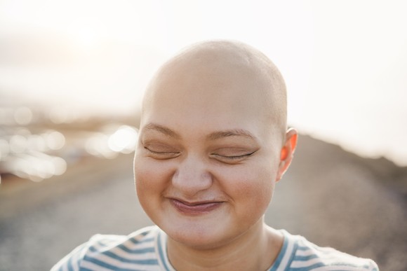 Someone in a striped top is smiling with their eyes closed.