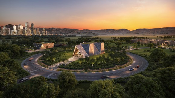 A rendering of an Oklo Aurora powerhouse. Rendering shows a powerhouse lit up in the evening, with a ring road around it and a city backdropping the image. 