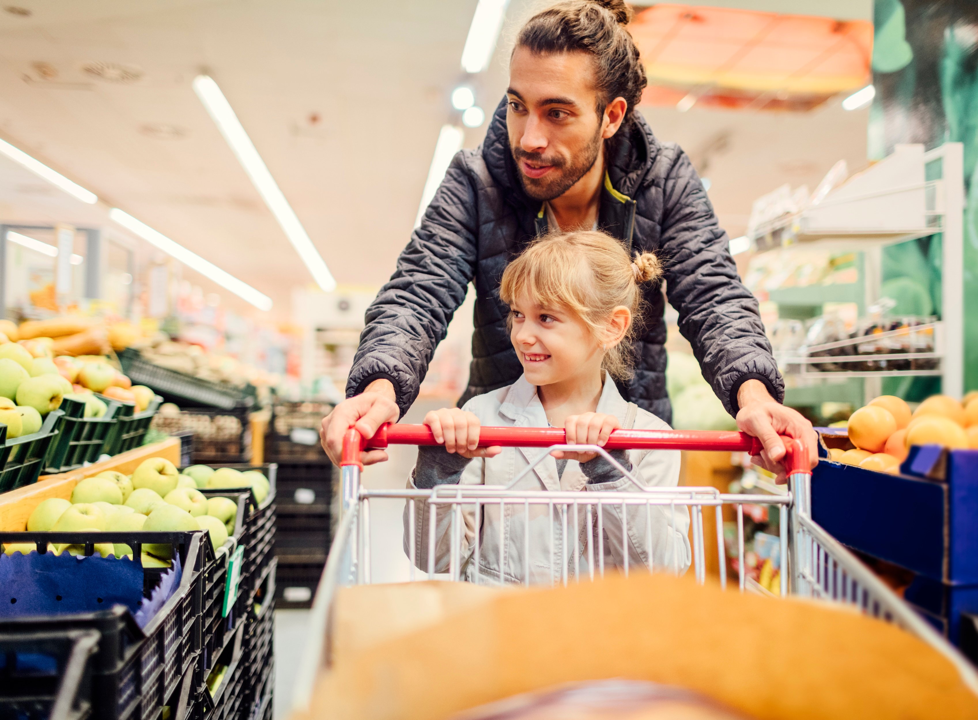 Parent and child shopping for produce. 