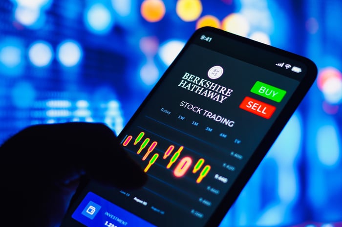 A smartphone displaying Berkshire Hathaway stock trading information.