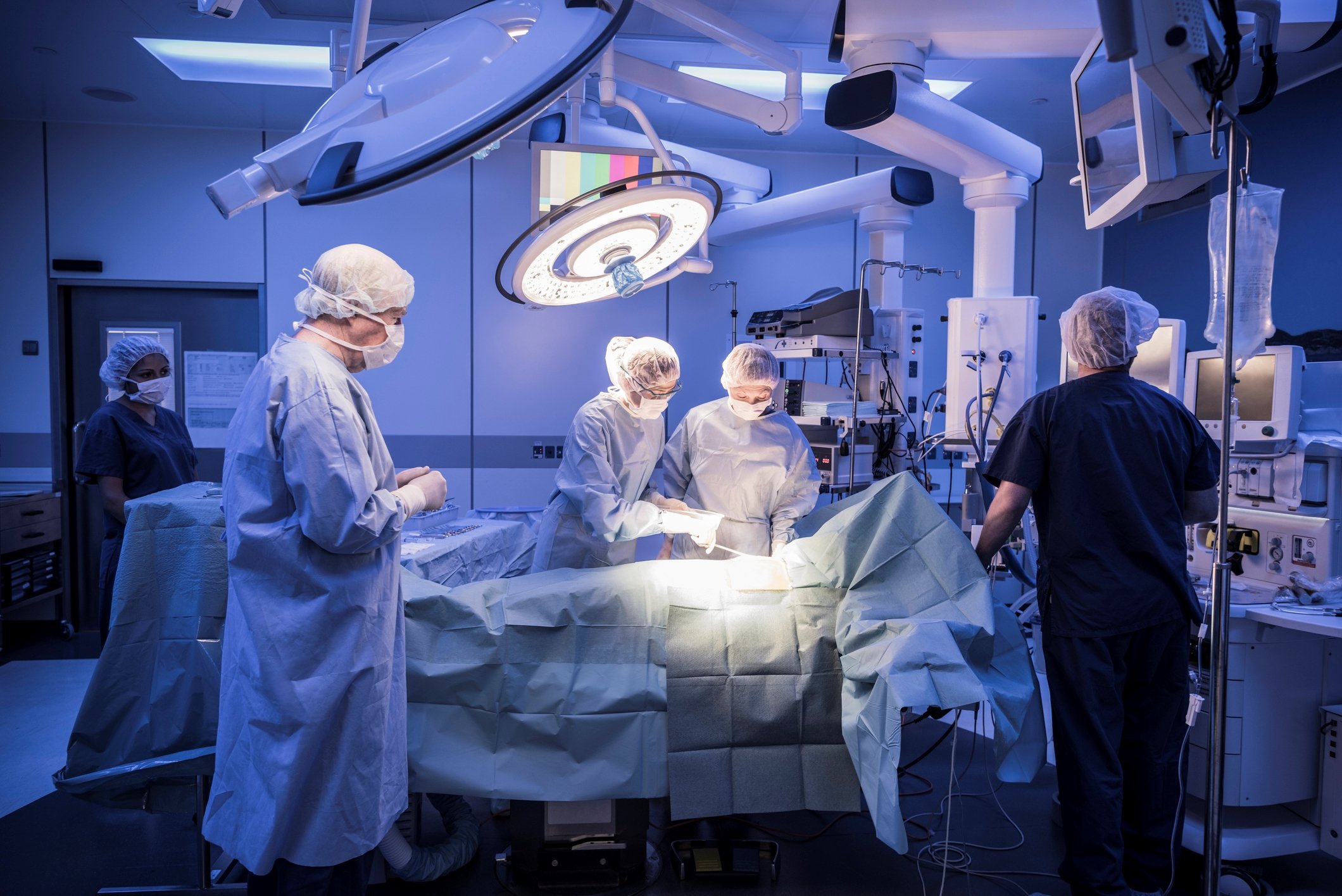 Surgeons standing around an operating table.