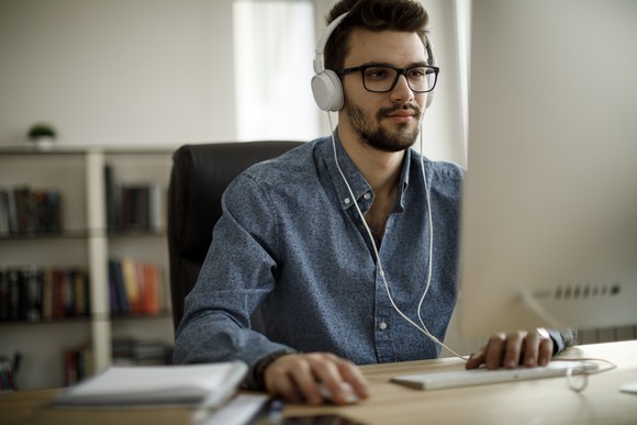 Person with headphones on using computer.