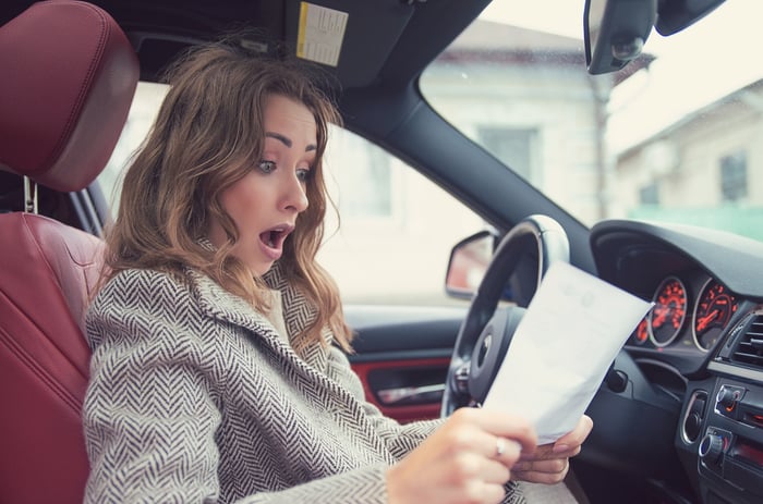 A driver looking at a piece of paper in surprise.