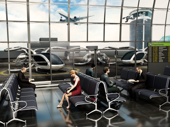 People sit at an airport waiting for their flight in an electric vertical takeoff and landing vehicle.