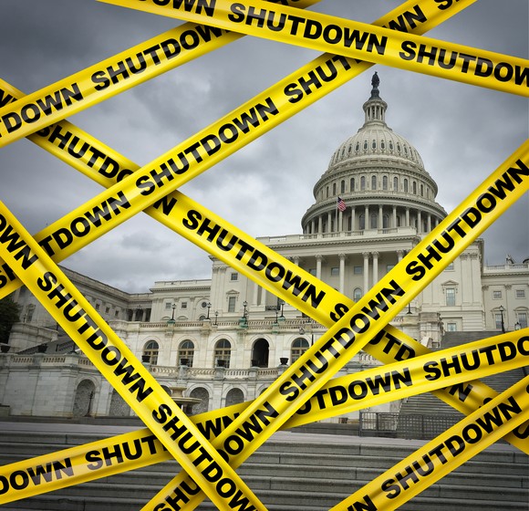 Caution tape that says Shutdown placed over a photo of the Capitol.