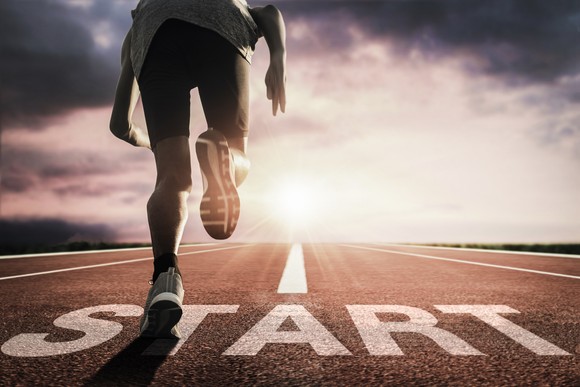 A person running from the start line on a track.
