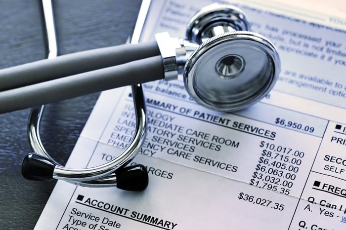 A stethoscope lying on top of a medical bill. 