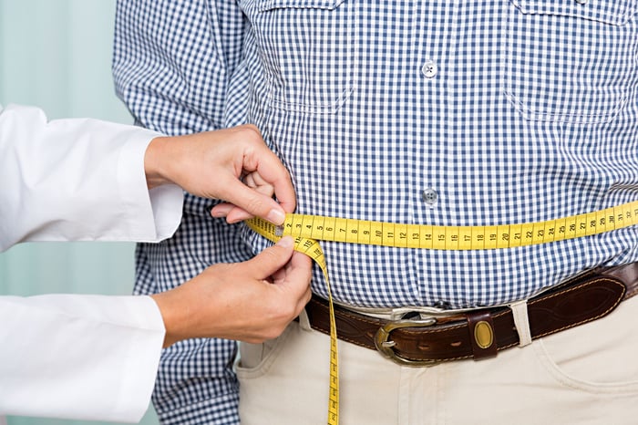 Doctor measuring a person's waist.