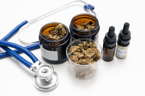 Cannabis and CBD oil next to stethoscope. 