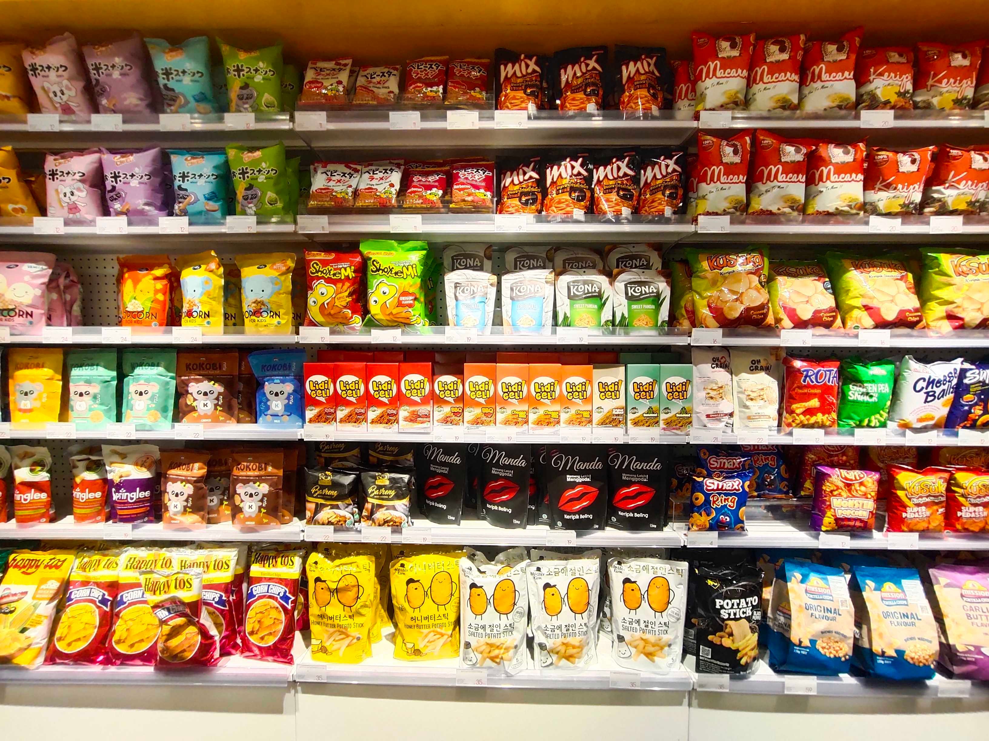 A grocery store's snacking and baked goods aisle stands on display with a wide array of brands.