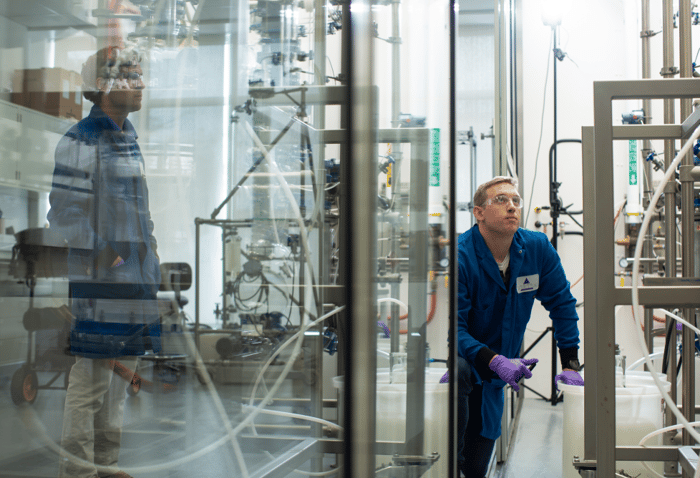 Two workers are shown in a Vertex factory.