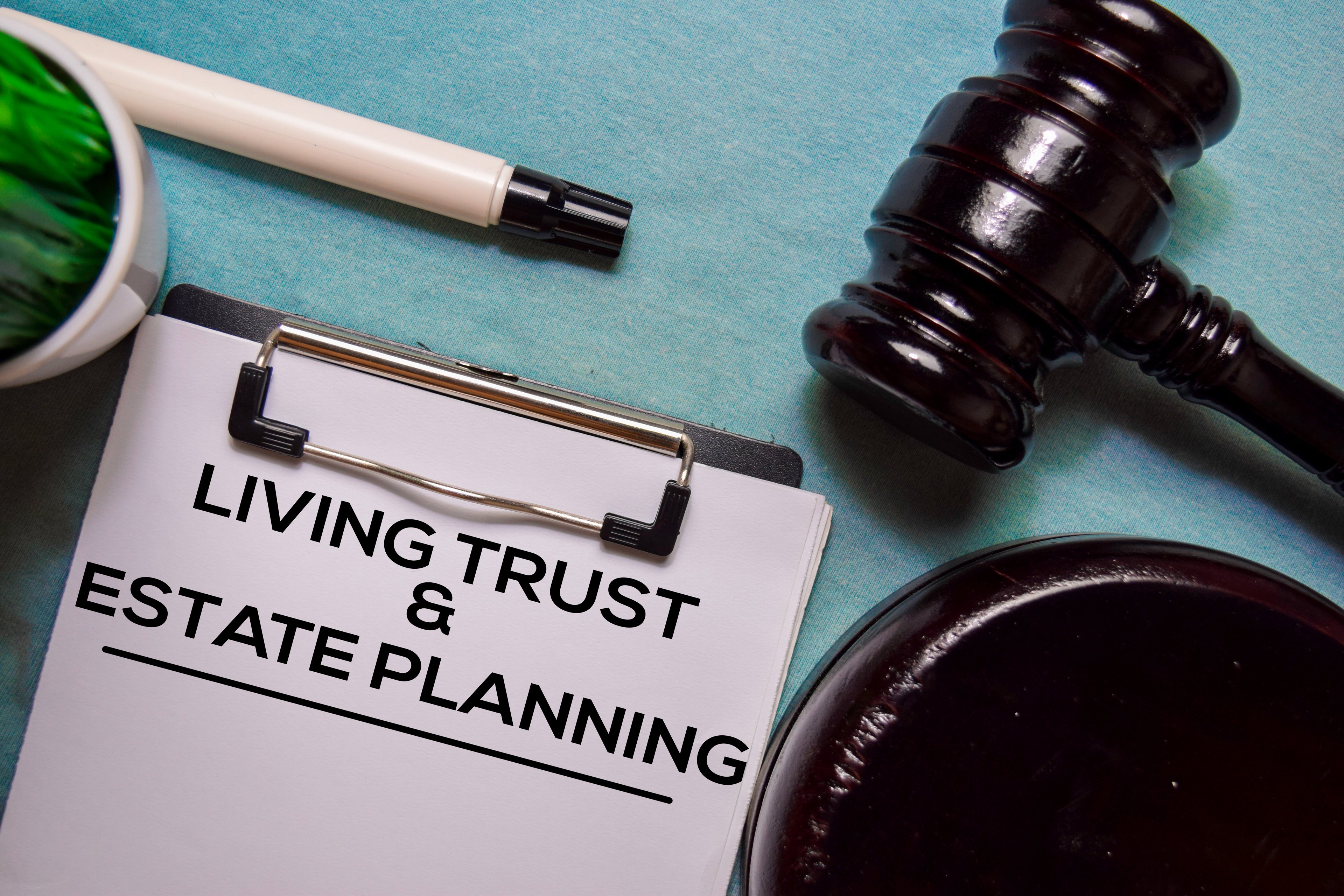 Clipboard labeled “Living Trust & Estate Planning” beside a judge’s gavel.