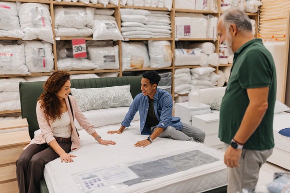 People shopping for a bed in a store.