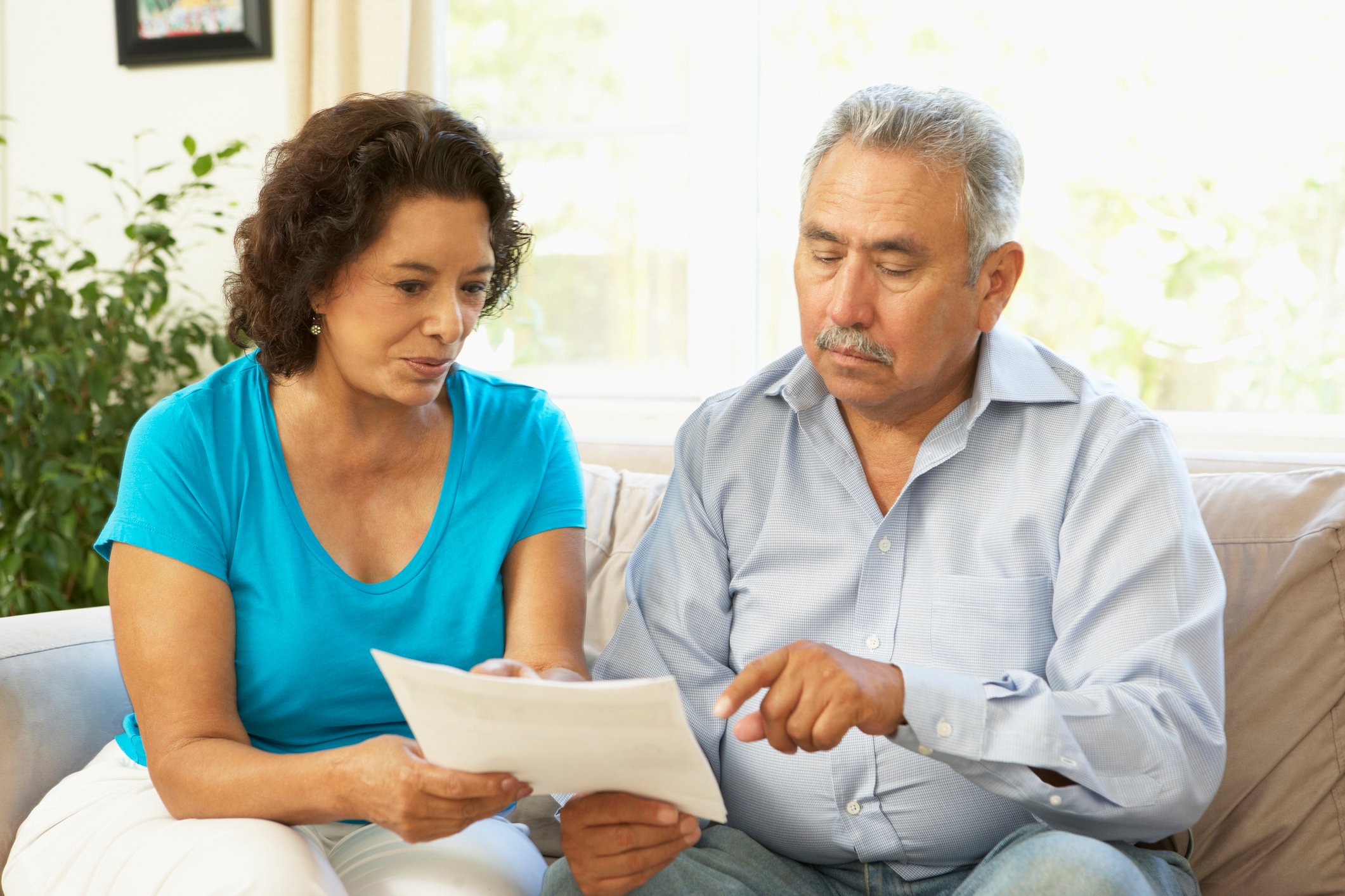 Senior couple pointing at document