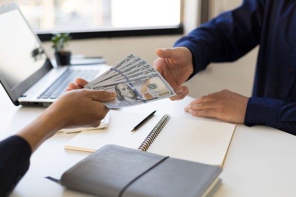 A person handing over money.