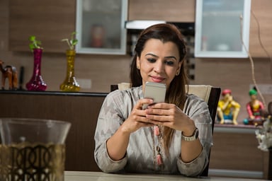 smiling woman uses smartphone.