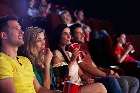 Moviegoers enjoying popcorn and a soda at a movie theater.