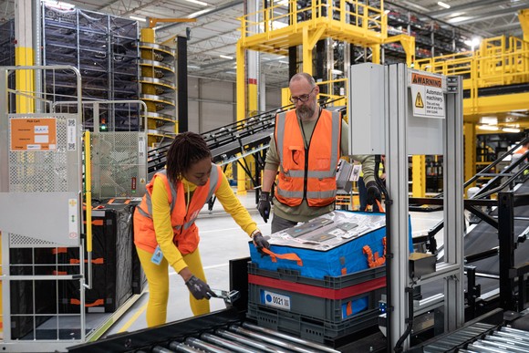 Amazon employees scan and pack merchandise.