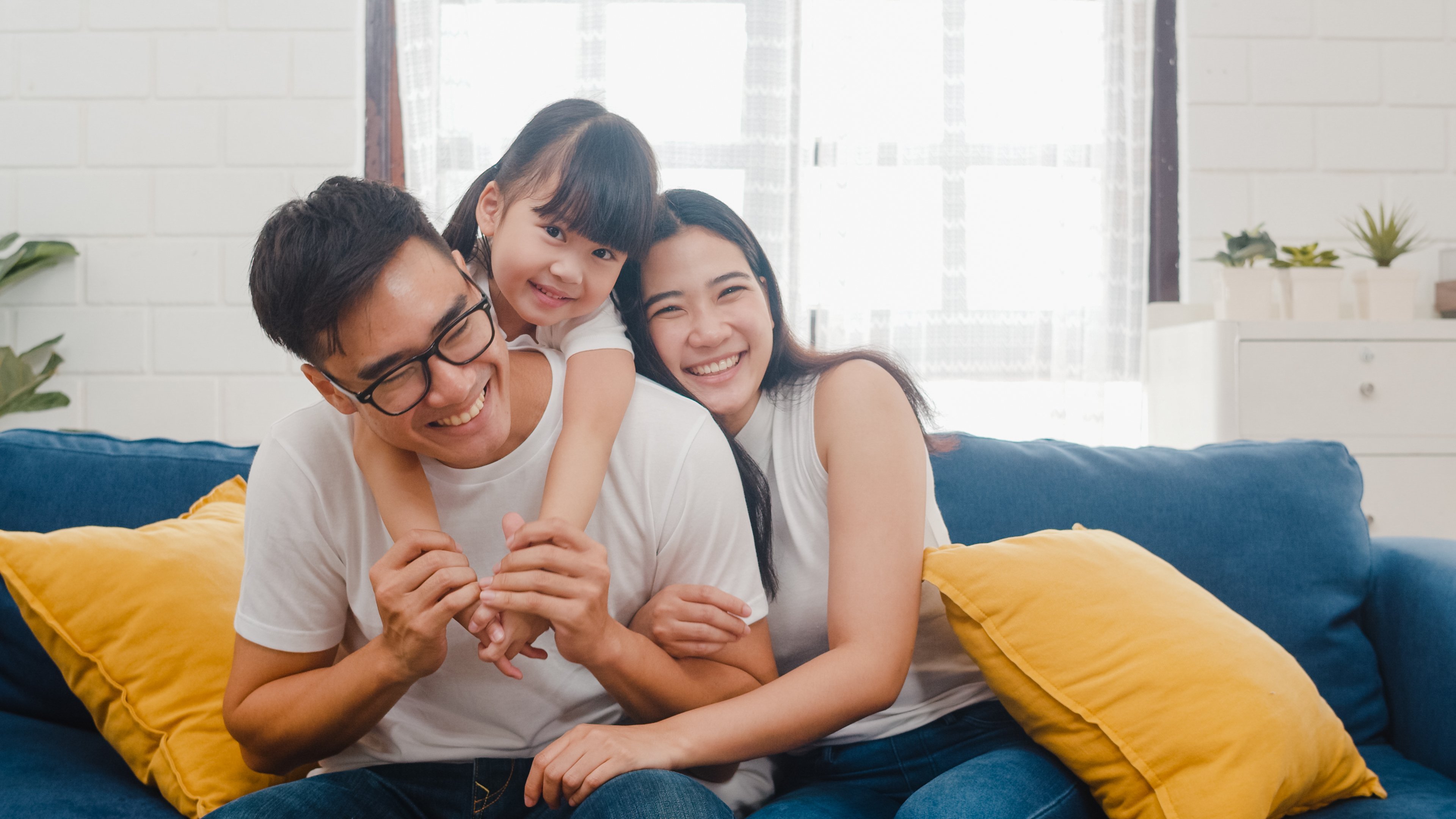 family cuddling on sofa at home