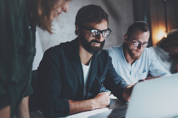 People smiling while they work on computers. 