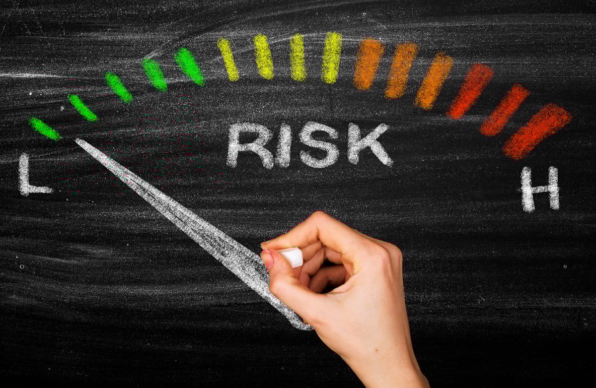 Chalkboard drawing of a risk dial shows low risk.