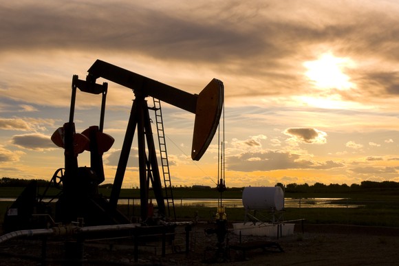 Oil pump jack against a sunset.