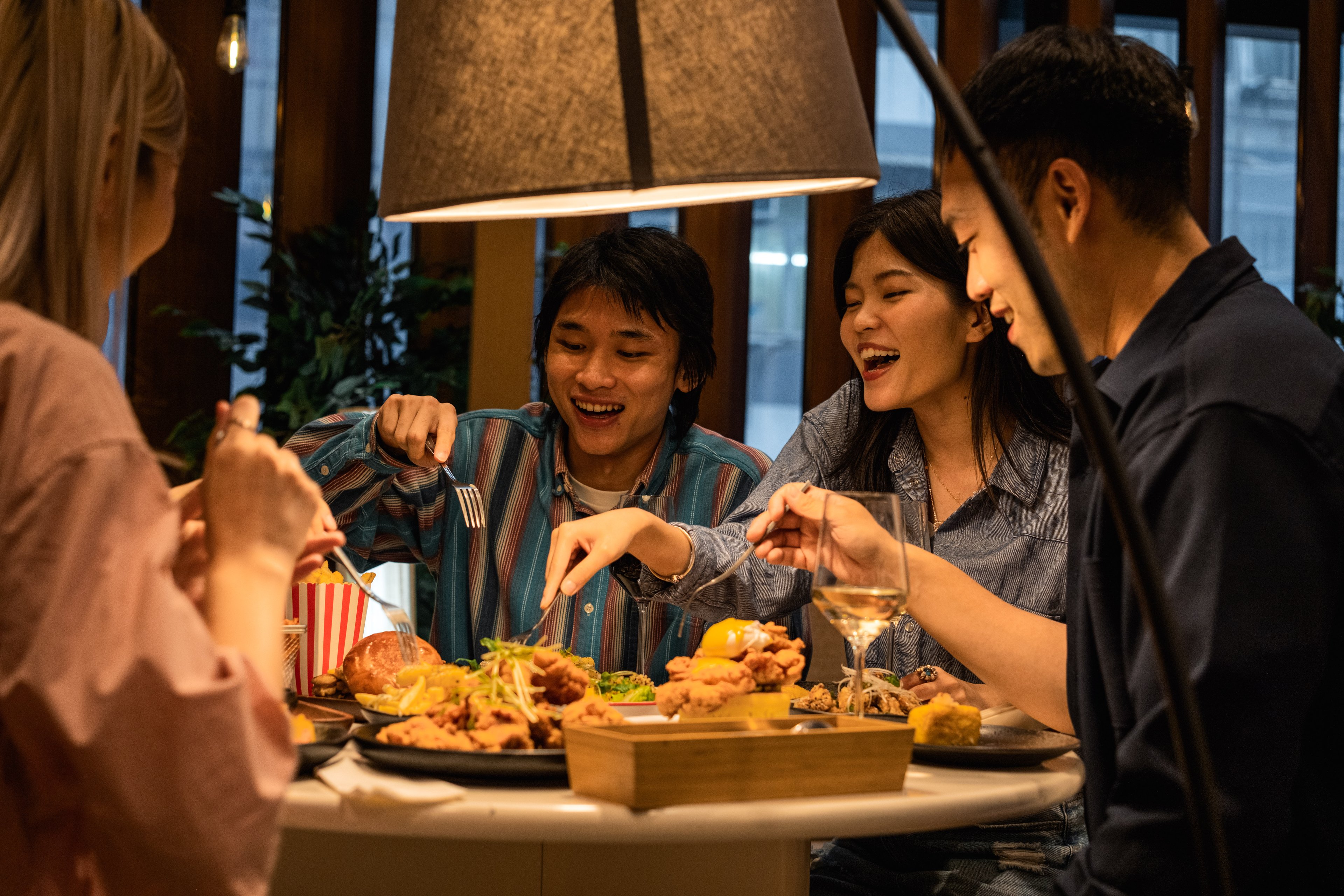 Happy family sharing a restaurant meal 1997883488