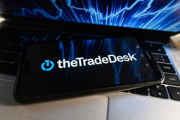 The Trade Desk logo on a phone sitting on a laptop keyboard.