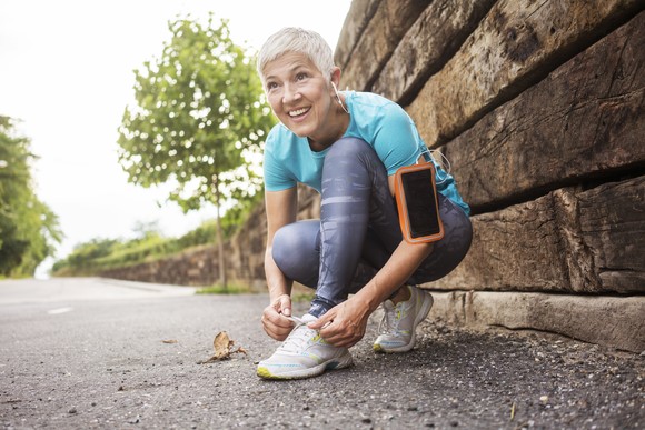 A person lacing up their sneakers for a run.