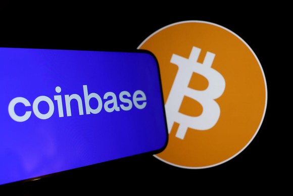 Coinbase logo with blue background displayed on a phone overlapping circular orange Bitcoin logo.