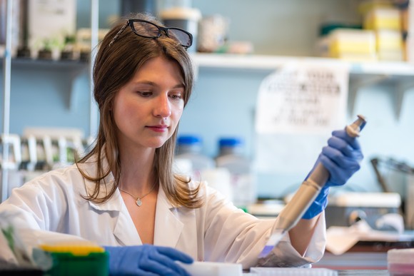 Female technician works with a medical test in a lab. 