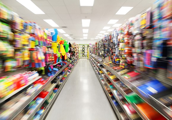 Walmart aisle with shelves on both sides displaying an abundance of consumer goods. 