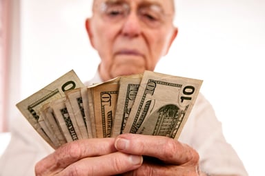 Person holding several 10 dollar bills.