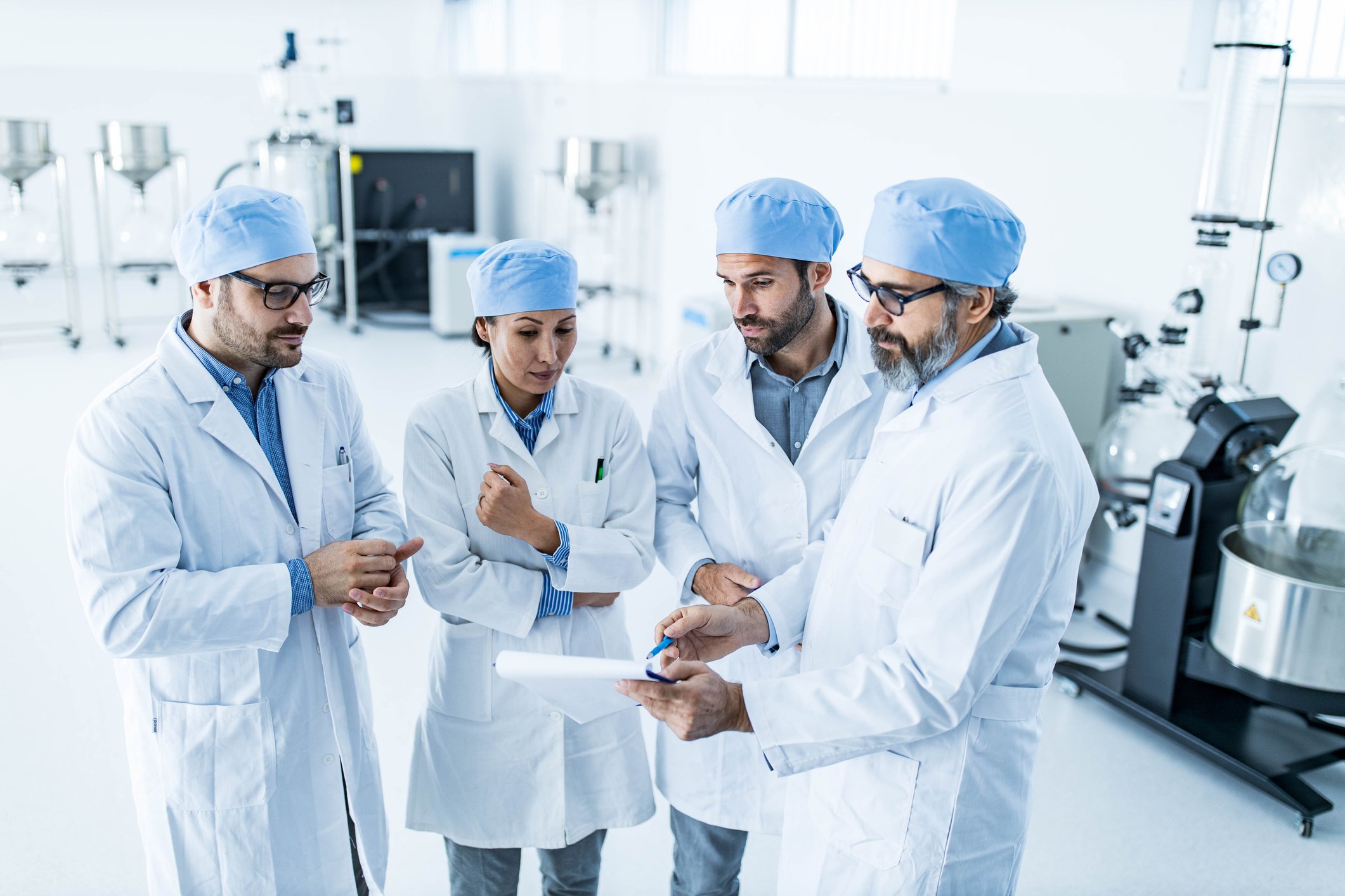 A team of four scientists reviewing results in a lab.