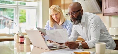 Serious couple looking at documents and laptop