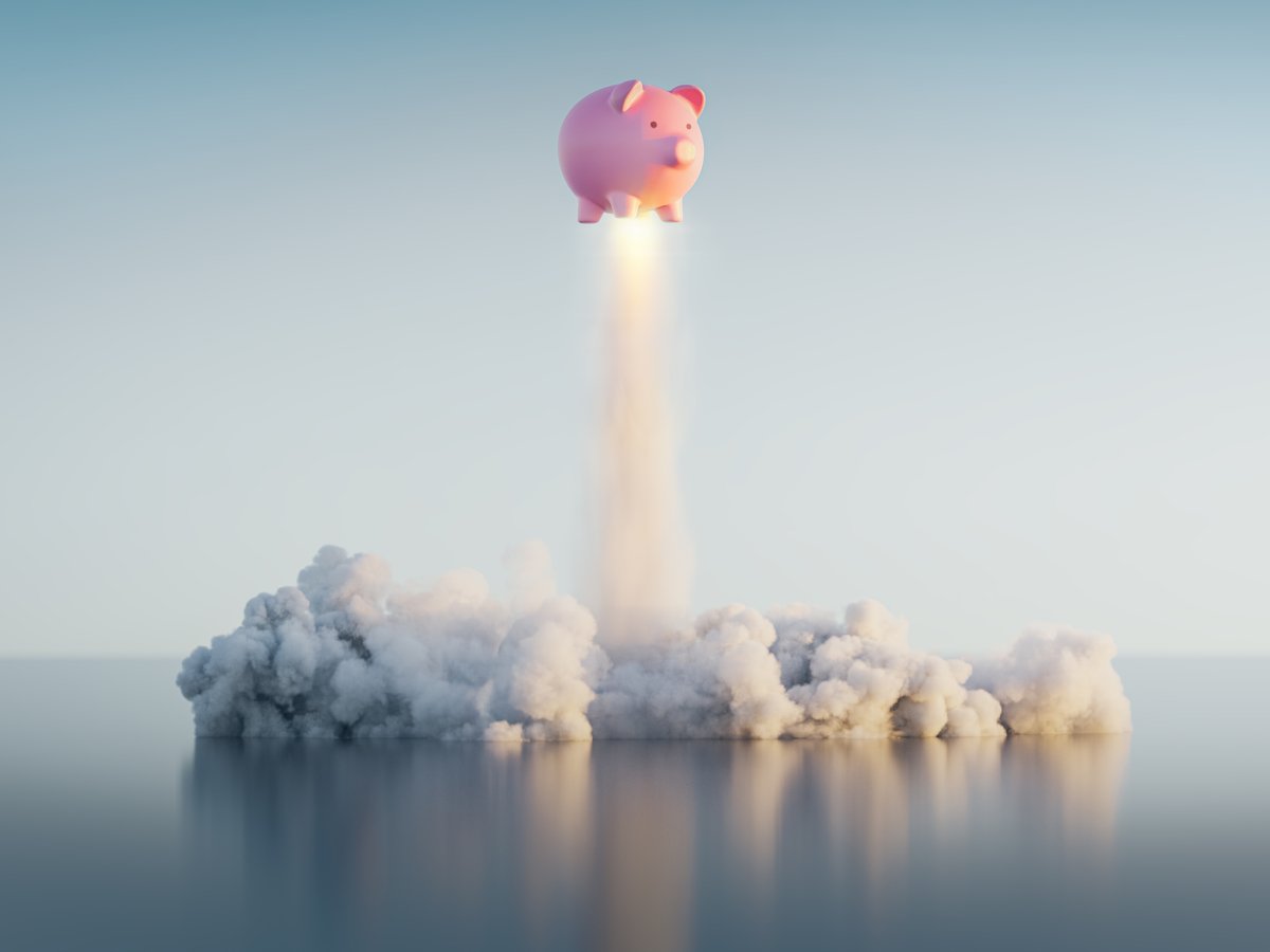 A piggy bank takes off like a rocket, creating a cloud of smoke on the ground.