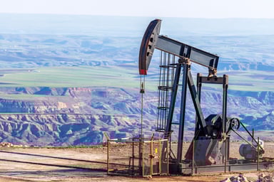 An oil pumpjack overlooking a valley. 