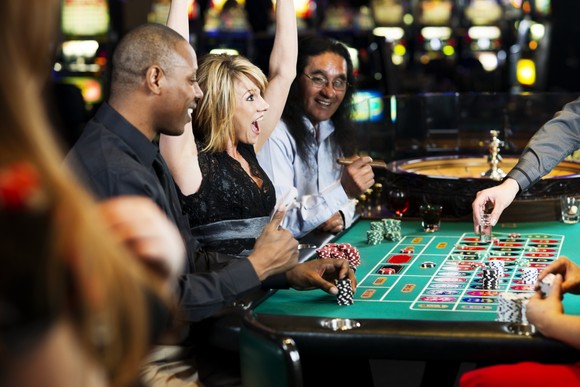 Woman cheering at a casino roulette table.