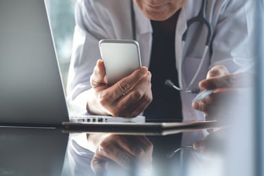 doctor working on laptop and smartphone