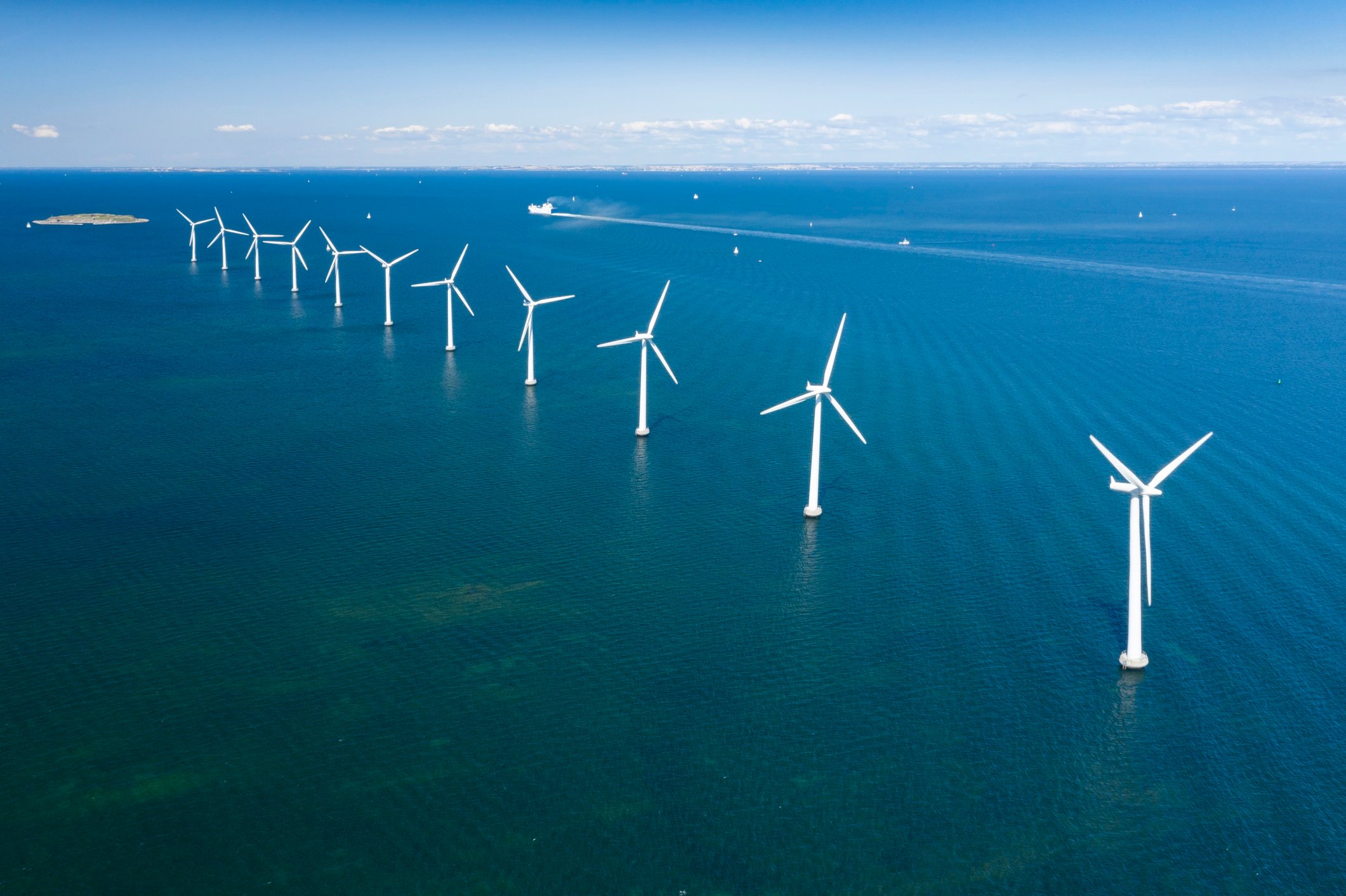 line of wind turbines in the ocean