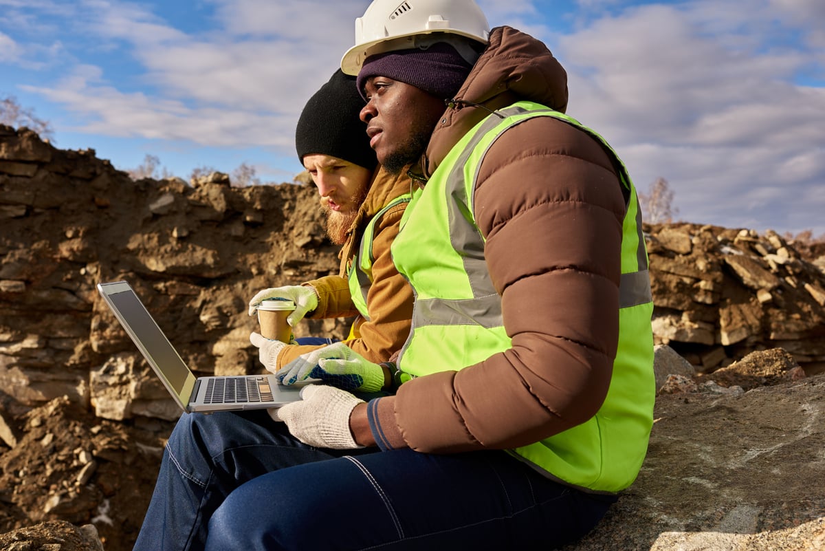Workers look out over a mine. 