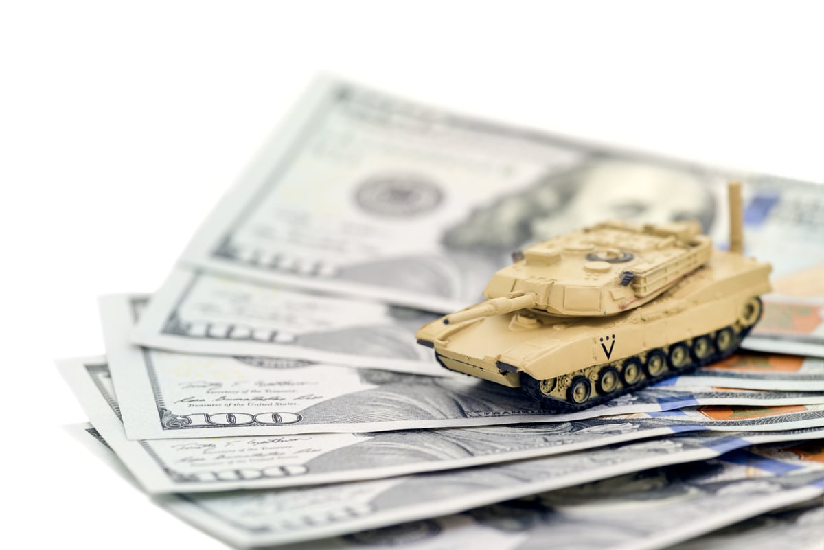 A toy tank on a pile of $100 bills.