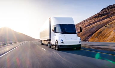 tesla semi truck on road near mountains
