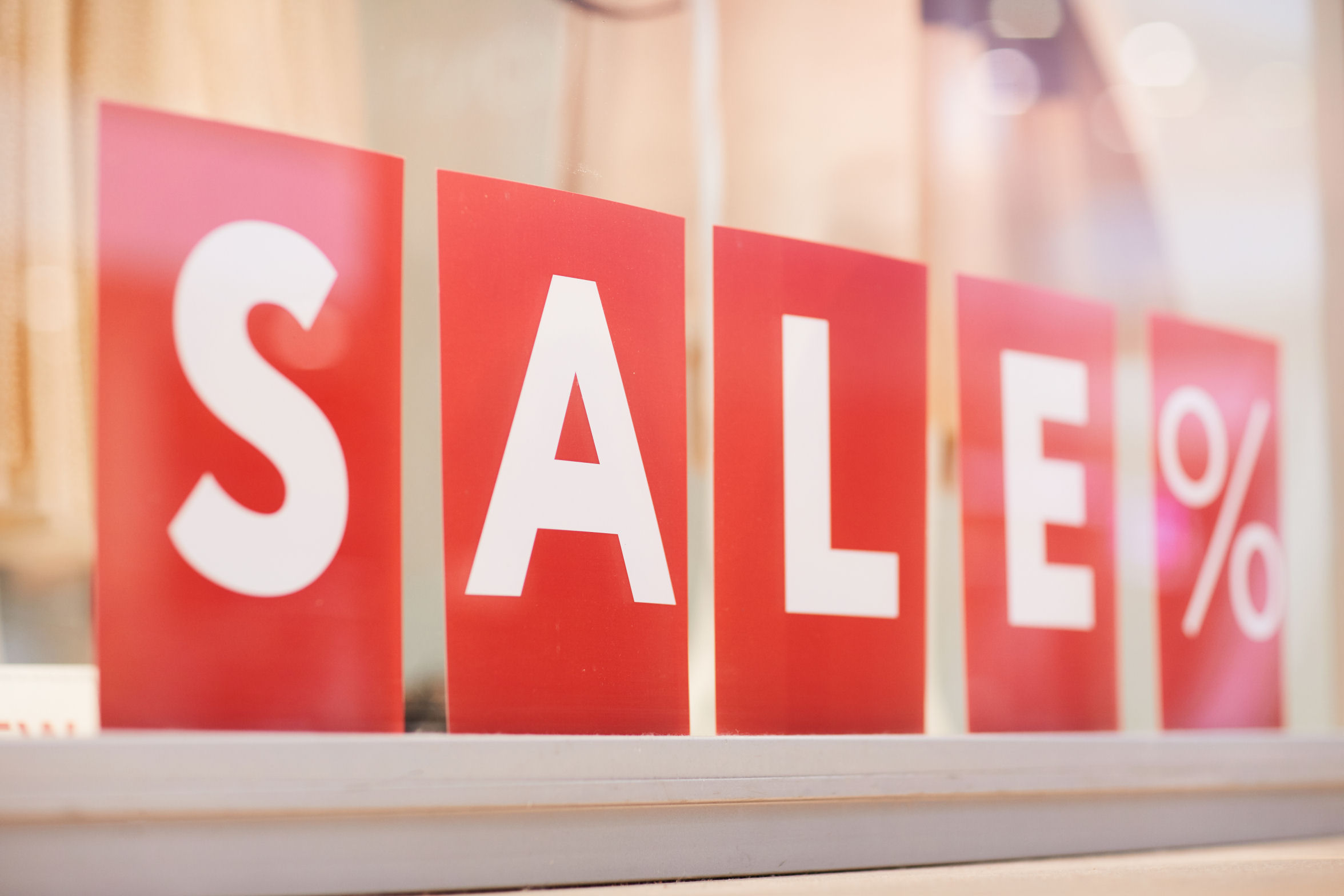 A sale sign sits in a store window. 
