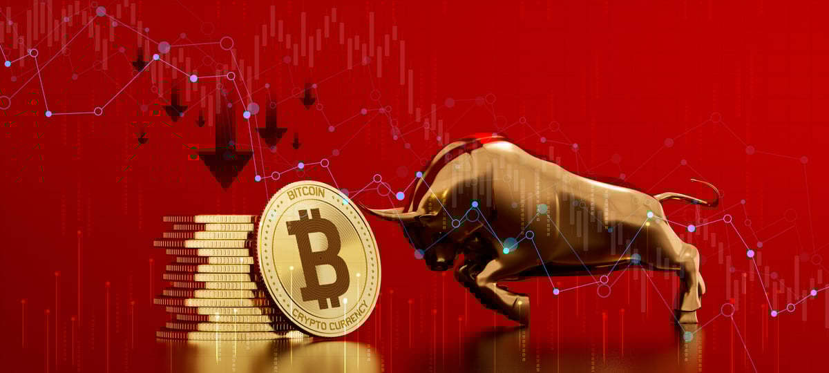 A bull and a stack of Bitcoins agains a red backdrop.