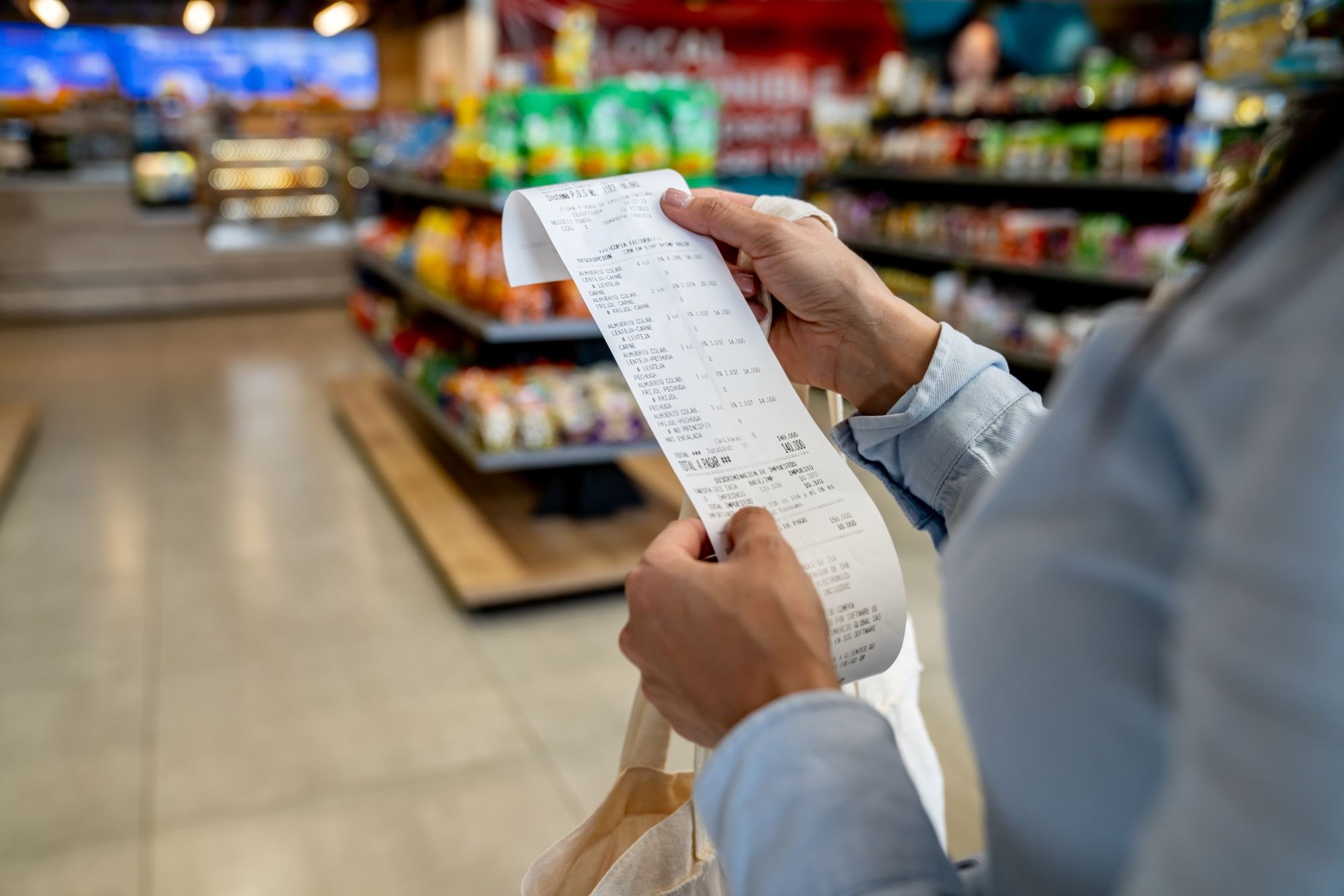 A shopper looking a their receipt in a store.