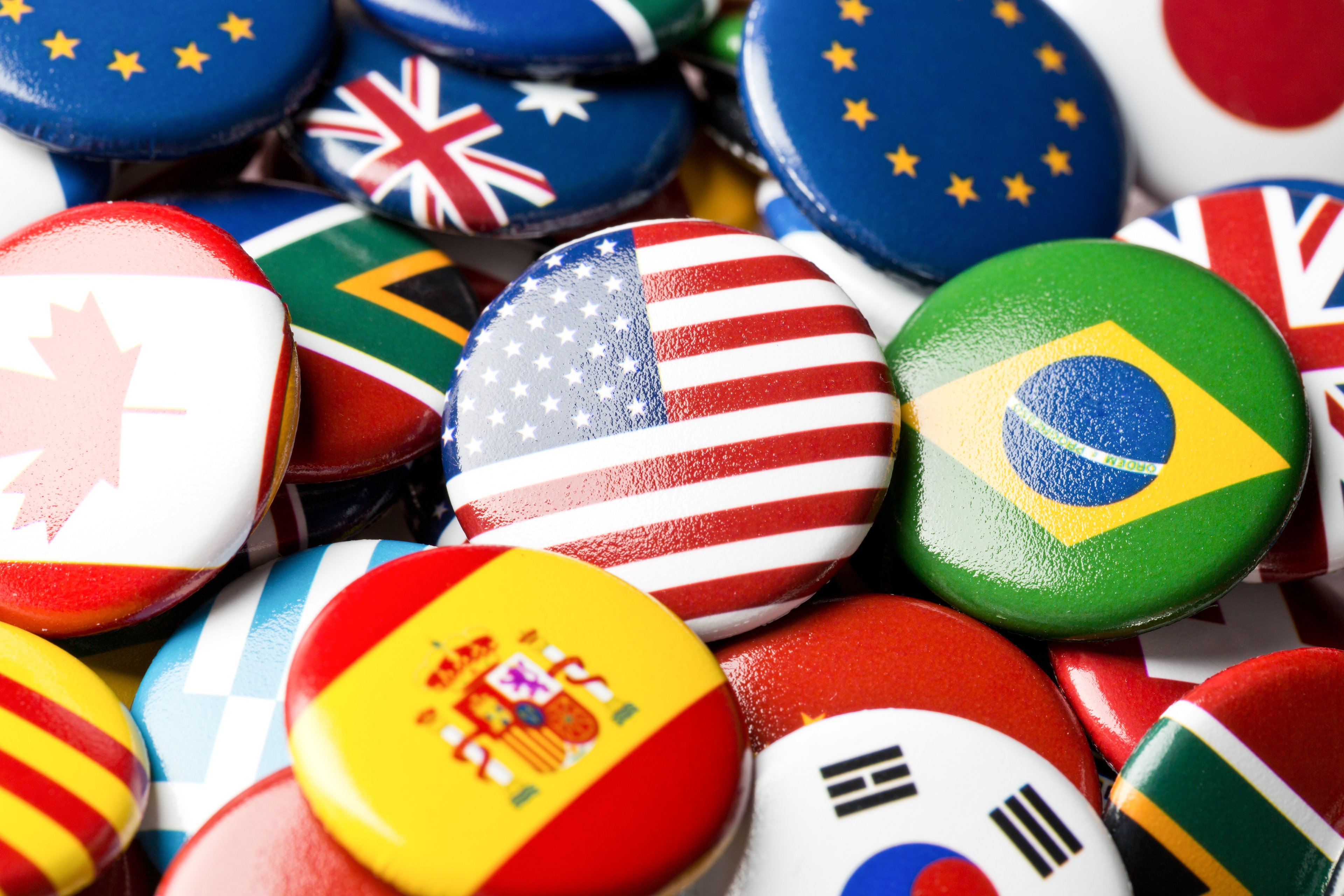 Buttons in a pile with different country flags on them.