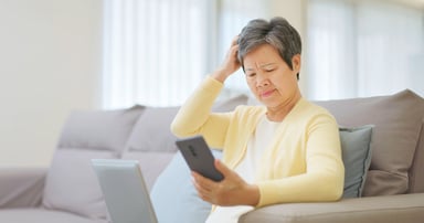 confused investor looks at smartphone.