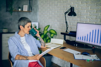 Person drinking coffee and looking at document