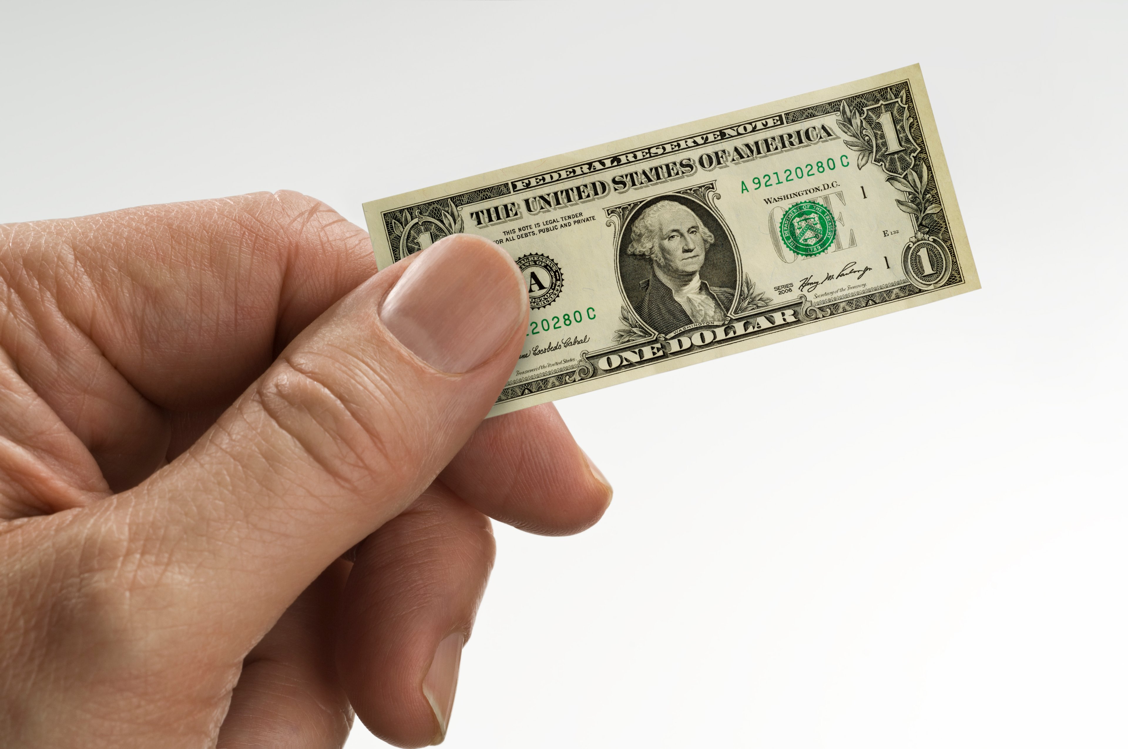 Hand holding a dollar bill.
